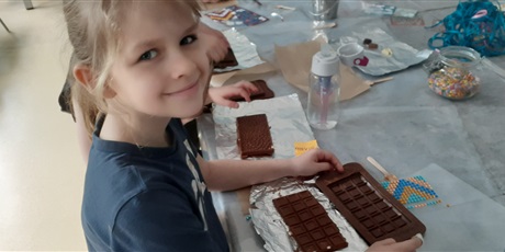 Powiększ grafikę: Dziewczynka z 1c pokazuje własnoręcznie zrobioną i wyjętą z formy czekoladę.