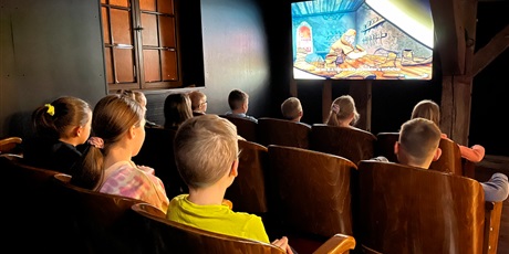 Powiększ grafikę: Dzieci z kl.2b oglądają film, o tym jak archeolodzy znajdują dawne przedmioty w ziemi.