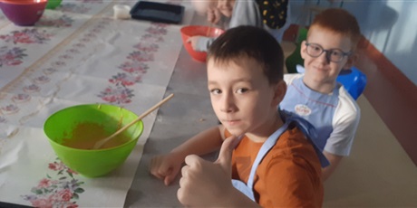 Powiększ grafikę: Dwóch chłopców z 1c uśmiecha się przygotowując ciasto dyniowe