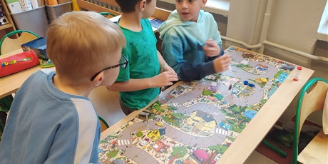 Powiększ grafikę: Trzej chłopcy grają w grę planszową.