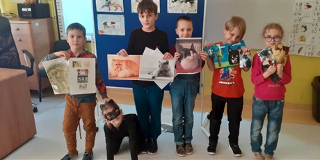 Powiększ grafikę: Kilkoro dzieci z 1c prezentuje na tle wystawy z kotami   przebranie oraz zdjęcia, rysunki i ciekawostki o swoich kotach.