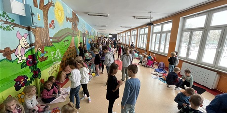 Powiększ grafikę: Uczniowie na holu dokonują zamiany różnych przedmiotów z innymi dziećmi.