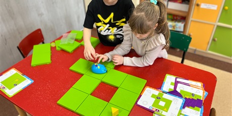 Powiększ grafikę: Dwoje dzieci uczy się kodować ruch myszki interaktywnej.