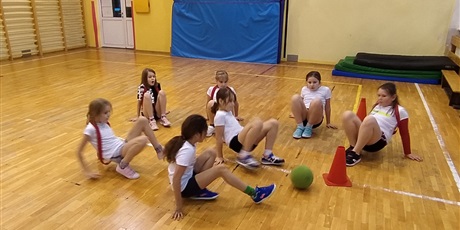 Powiększ grafikę: Dziewczynki w sali gimnastycznej grają w chińską piłkę.