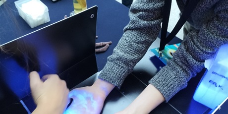Powiększ grafikę: Uczeń ogląda swoje dłonie w świetle UV