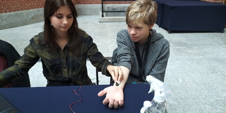 Powiększ grafikę: Studentka biologii przeprowadza EMG-pobudzenie mięśni ręki jednego z uczniów