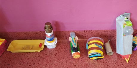 Powiększ grafikę: Pod ścianą stoją zabawki wykonane z surowców wtórnych.