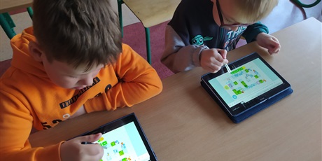 Powiększ grafikę: Dwoje uczniów koduje klocki Lego na tablecie