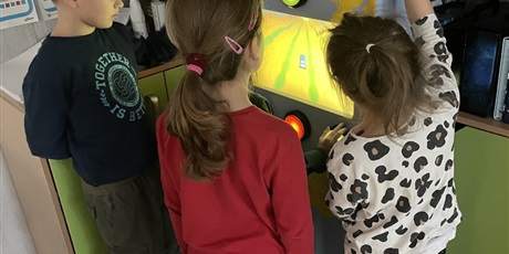 Powiększ grafikę: Dzieci obserwują grę kolegi na automacie.
