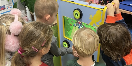 Powiększ grafikę: Dzieci obserwują grę kolegi na automacie.