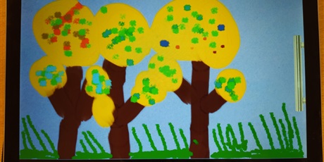 Powiększ grafikę: Na ekranie tabletu rysunek jesiennych drzew.