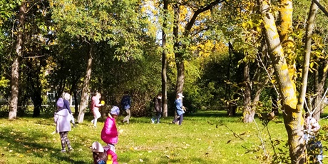 Powiększ grafikę: Dzieci w parku zbierają liście.