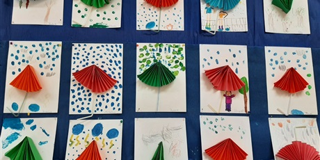 Powiększ grafikę: Na tablicy zawieszone prace plastyczne przedstawiające parasolki.