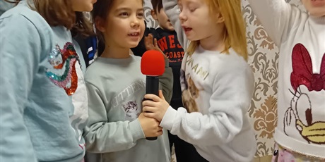 Powiększ grafikę: Trzy dziewczynki śpiewają trzymając w dłoniach mikrofon.