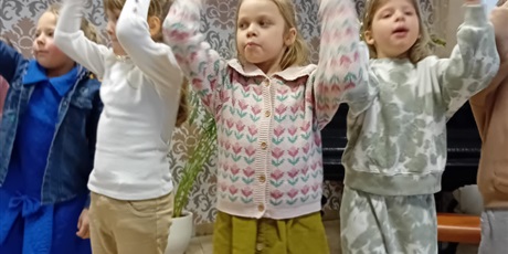 Powiększ grafikę: Dziewczynki śpiewają piosenkę mając ręce podniesione do góry.