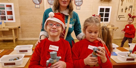 Powiększ grafikę: dwie dziewczynki stoją z elfem i trzymają robociki z drewna