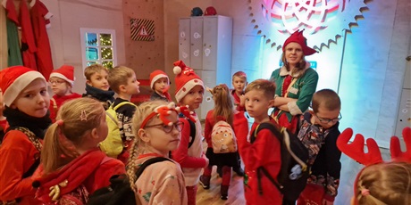 Powiększ grafikę: dzieci ubrane na czerwono stoją obok elfa