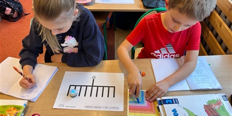 Powiększ grafikę: Uczniowie doskonalą tabliczkę mnożenia używając robocika Ozobota i kostek do gry.