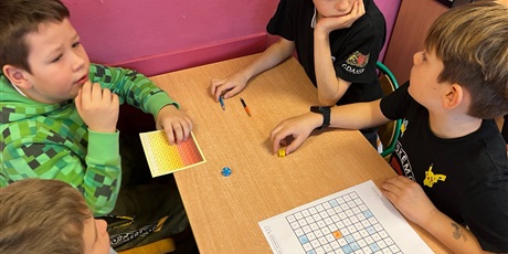Powiększ grafikę: Czworo uczniów doskonali znajomość tabliczki mnożenia podczas gry matematycznej