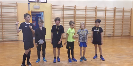 Powiększ grafikę: Dzieci z klasy 3b stoją z medalami na szyi na sali gimnastycznej.
