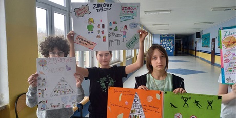 Powiększ grafikę: Grupa uczniów trzyma w rękach wykonane przez siebie plakaty o tematyce zdrowotnej.