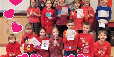 Powiększ grafikę: Dzieci ubrane na czerwono, w rękach trzymają Walentynki i lizaki w kształcie serca.