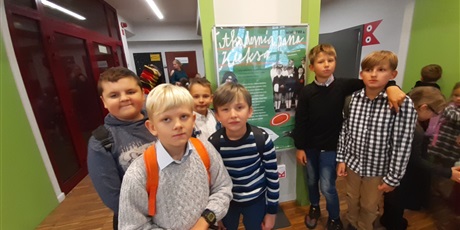 Powiększ grafikę: Chłopcy stoją przy plakacie reklamującym spektakl Akademia Pana Kleksa