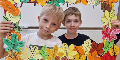 Powiększ grafikę: dwaj chłopcy trzymają w ręku fotobudkę z jesiennych liści